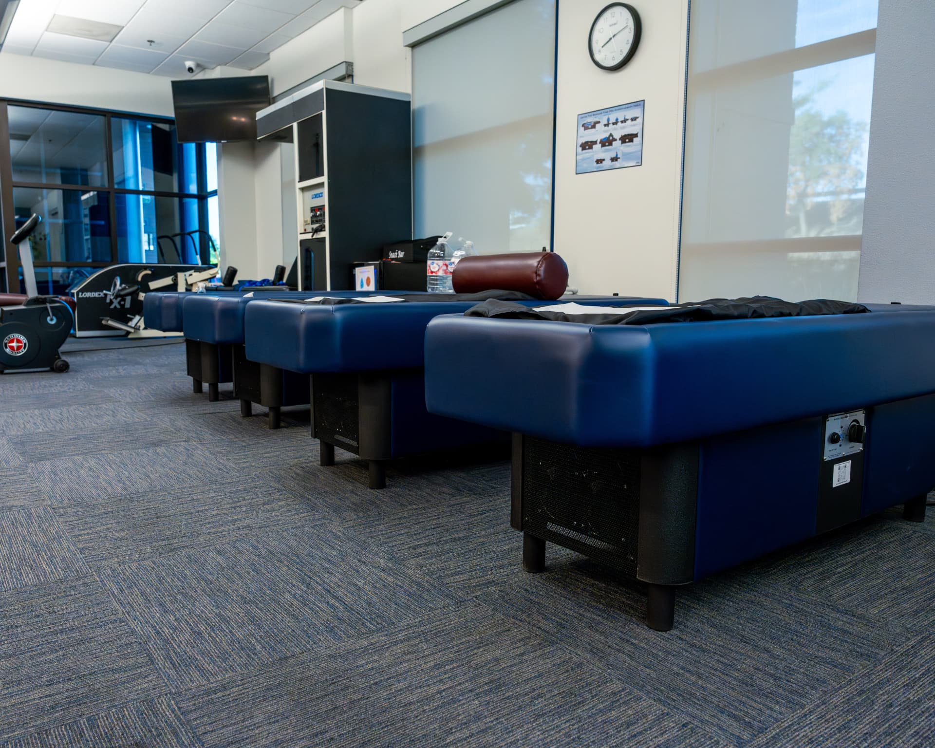 Row of chiropractic treatment tables at First Health Medical Center
